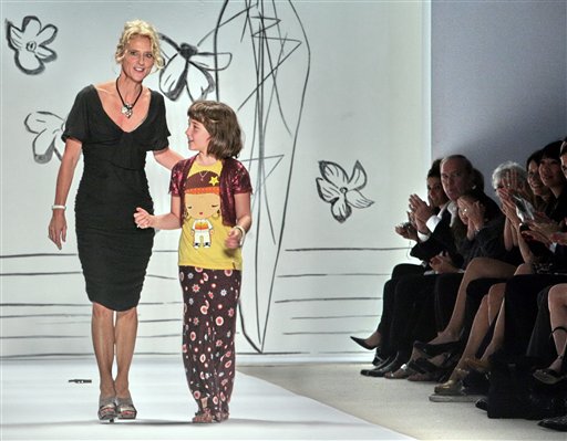 Following the showing of her 2008 spring collection, fashion designer Nanette Lepore reacts to applause as she walks with her daughter Violet Savage on the runway, during Fashion Week in New York, Monday Sept. 10, 2007. 
