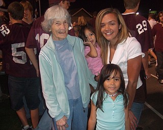 Feature twirler instuctor Rickie Rock(far left) , two future twirlers Marraya(standing) and Jasmine (held) and former Spartan Twirler Captain Brittany Schiffauer (far right) watch the halftime show at the Boardman vs. Hoover game.