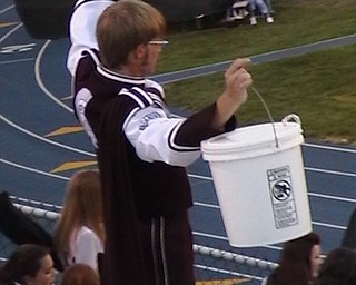 Spartan Band Member Standing holding his instrument in the air.