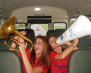 Fitch Varsity Cheerleaders, Sara McAllister and Britny Benett, belt out all the right notes as they prepare to cheer on the football team while riding the bus to their game in Jackson
