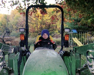 Dylan George, son of Angela and Erik George and grandson of Cheri and Stan Saveet of New Midletown, gets a ride on grandpa's tractor.