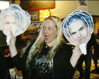 Jess McElhinny of Youngstown passes out "Jimmy's on a stick" cutout faces of former congressman, Jim Traficant, during a birthday party Thursday.