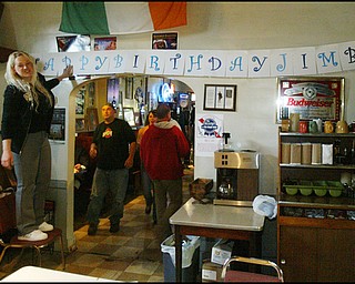 Jess McElhinny of Youngstown hangs a banner during a birthday party for the currently jailed ex-congressman, Jim Traficant, at the Royal Oaks Tavern Thursday evening.