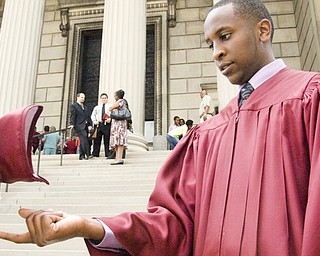 Eric Masagara, 18, of Youngstown received an academic scholarship of nearly $20,000 to the University of Michigan, where he is thinking of pursuing a career in the sciences. Here he is on the steps of Stambaugh Auditorium challenging physics with his mortarboard.