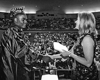 Dwaine Thomas accepts his diploma from board of education member Lauri Kuszmaul.
