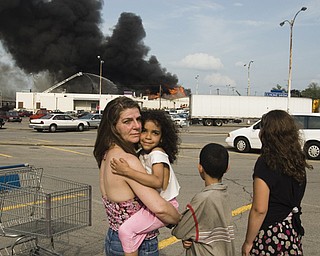 L-R, Youngstown residents Joann Sarbaro, Dreama Williams, 5, Jerome Williams, 9, and Cher-vea Sarbaro, 10, watch the fire from an adjacent parking lot.