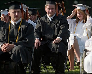6.8.2008
Carrie Ritzler (at right) keeps her hat from blowing away during Springfield High School's commencement ceremony Sunday evening at the school's stadium.