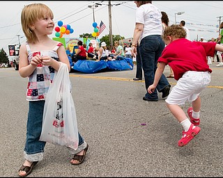 7.4.2008
Cadence Pounds (4), of Austintown, enjoys the free candy as Matthew Fryfogle (2), also of Austintown, leaps out to grab a piece left behind during the Fourth of July Parade in Austintown.