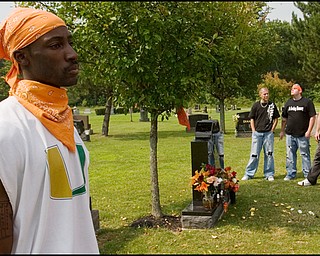 7.6.2008
Jimmy Hughes Jr, of Youngstown, stands in reflection among fellow motorcyclists paying their respects at the grave of Matthew Adam Tynal, who died from a motorcycle accident on July 1, 2007. "It makes you feel free," Hughes said of riding motorcycles while donning orange bandannas, the color of Tynal's motorcycle and the motorcycle club, "The Lost Boyz," found in his honor.
