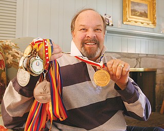 FISTFUL OF MEDALS: Nick Carson of Poland, a dual kidney transplant recipient, shows off the medals he has won in swimming and cycling events at U.S>, World and Australian Transplant Games, including gold he won swimming the butterfly at the World Games in London, Ontario. He will attend this weekend's U.S. Transplant Games in Pittsburgh, but will not compete for health reasons.