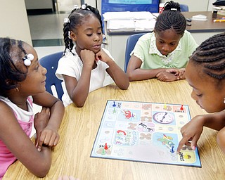 Youngstown Community School students left-to-right Jalaya Kitchen, 7, Johnae Coleman, 7, Nyla Bass, 8, and Jay'Lynne Armour. 8. play a board game during a student at Youngstown Community School, during a 4 week summer intervention program at the school Wed 7-9-08. The program which ends Friday 7-11 stresses math and reading skills to improve test scores and foster a love of learning. About 45 students participated in the program.