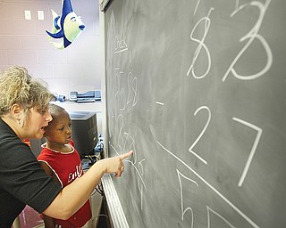 Cheriese Farkas, a teacher at Youngstown Community School works with Markies Hopkins, 7, a student at the school, on a math problem during a 4 week summer intervention program at the school Wed 7-9-08. The program stresses math and reading skills to improve test scores and foster a love of learning. About 45 students participated in the program.