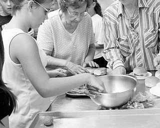 Tori Augustine 10, of Boardman learns the making of a meatball sandwich at the Italian Heritage week from Margurite Gondol and Lisa Orlando at the Italian Heritage week 100th anniversary of Our Lady of Mount Carmel Church