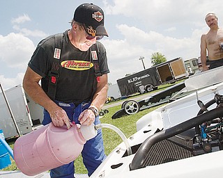 [7.5.2008]

Bob Bastian, of Warren, fills the fuel cell on his 1975 Vegas Station Wagon, a Super Pro Class dragster, at Quaker City Drag Strip July 5, 2008.

Bastian fixed and assembled the car, which he has been racing for 10 years, with the help of Abruzzi Transmissions, of Warren, and Koffel's Place who does the engine work.

Bastian has racing since 1964 primarily dragsters since 1964 with a brief stint of stock car racing.

Bastian and his daughter describe the community at the Quaker City Drag Strip as "one big family" where "the kids have grown up together on the weekends" and people gather not only on the track but also off the track in one case taking a trip to Six Flags.

"I've thought about giving it up every weekend I lose," says Bastian referring to his interest in drag racing, " but 10 minutes later I'm ready to go again."

"I've lived on adrenaline all my life," says Bastian, who spent 31 years as a firefighter, and considers adrenaline and competition as major appeals of drag racing.

"Me and my daughter are competitive together," says Bastian, " and she'll be a good racer when she gets in a big car." 