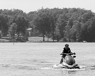 [7.5.2008] Eric Houck, of Boardman, rides a jetski July 5, 2008 at Lake Milton where his in-laws have a place on the lake. Houck hasn't noticed a decline in jet ski usage on the lake, but has noticed "quite a few less boats."