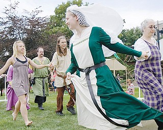 [7.12.2008] Laura Huffman, of Wadsworth, and Jenny Blazek, of Farmington, dance the Trenchmore beside a tent belonging to the Society for Creative Anachronism at the YSU Summer Festival of the Arts along Wick Ave. Saturday afternoon. The group of medieval enthusiasts recreate the tournament style fighting, craft making, drama, music, camping, and cooking of the era citing the importance of learning history beyond simply reading about it and by experiencing it as well. More information can be found at the local chapter's website www.rivenvale.org/ or the national website www.sca.org. 
