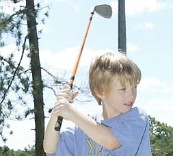 Andy Garr, 8, of Canfield tees off at Mill Creek Par 3 during Golf Camp.
