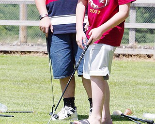 Tyler Blake, 13, of Sprinfield RIGHT. sinks a putt while Brandon Benson, 14, of Campbell looks on during a youth golf camp at Mill Creek Park par 3 course.