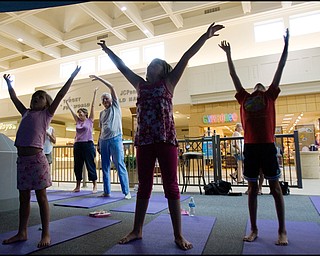 7.17.2008
Michelle Cristo and John Mrofchak, both of Warren, practice Yoga behind Zoe Bowman (7), of Vienna, Anna Cristo (8), of Warren, and Kira Bowman (8), also of Vienna, during Yoga for Kids, a summer workshop at Eastwood Mall offered offered by the Art Outreach Gallery and sponsored by American Gladiators Fitness Center.