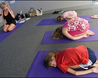 7.17.2008
(FRONT TO BACK)
Kira Bowman (8), of Vienna, Anna Cristo (8), of Warren, and Zoe Bowman, also of Vienna (7), practice yoga before instructor,Judy Kay, of Howland, during Yoga for Kids, a summer workshop at Eastwood Mall offered offered by the Art Outreach Gallery and sponsored by American Gladiators Fitness Center. "It has totally changed my life {(I began)} feeling better about life and myself, its keeping me young" says Kay of yoga which she has taught for 35 years, "thats what i want to give back to the kids and you don't need any special equipment you can do it on your own."