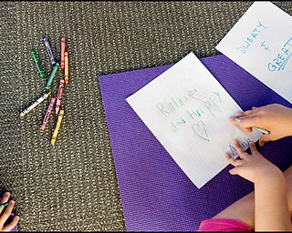 7.17.2008
Anna Cristo (8), of Warren, writes "relaxed and happy" while her grandfather choses the words "sweaty and great" to describe his experience of participating in a meeting of the Yoga for Kids workshop put on by the Art Outreach Gallery at Eastwood Mall.