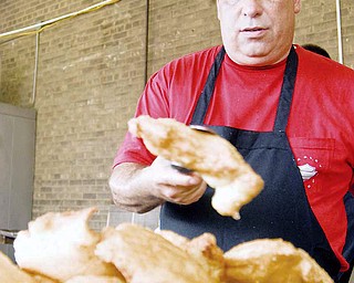 SAY CHEESE: Denny "Boogie" Virgallito of Niles places another cheese puff on a tray to cool. Virgallito was just one of many volunteers for the Mount Carmel Festival on Sunday.