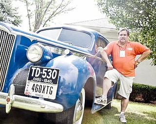 CLASSIC RIDE: Dr. Bob Watson, event organizer for the Packard car show, poses with his electric blue Packard 110 sedan. Walton and fellow auto enthusiasts brought theirs rides to the show Sunday.