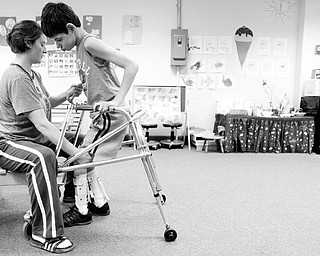 HELPING HAND: Meghan Crowley helps 13-year-old Matthew Mace in an exercise to move his legs during the Miracles Unlimited summer camp. The camp helps children who suffer from motor disabilities.
