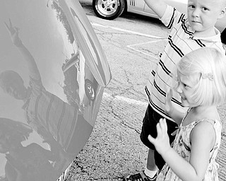 SEEING DOUBLE: Mary Kay Vencel, 3, and her brother Matthew, 5, of Warren stop and admire their reflections off the hood of a Triumph convertible. The car was one of many that took part in the Packard auto show Sunday.