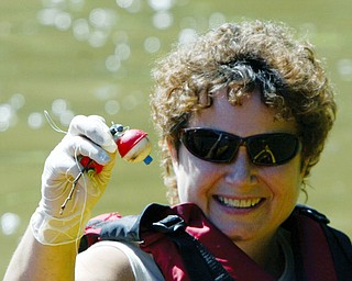 Sue Reniff of Boardman shows a plastic bobber she pulled from Lake Glacier during a clean up effort Thursday by a group of kayakers. wd lewis