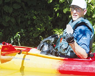 Mark Dolak of Austintown shows a piece of plastic litter he pulled from Lake Glacier in MillCreek Park during a clean up effort by a group of kayakers. WD LEWIS