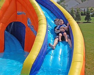 This is a picture of big brother Connor, 10 taking his little brother Dominic, 17 months down a backyard waterslide to cool off.  Picture taken by mom, Kim Yurich of Poland.