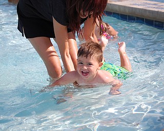 This is a picture of Dominic Yurich, 17 months learning to swim with friend Pamela Cougras while mom, Kim Yurich is capturing the moment.