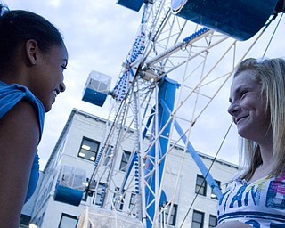 The crowd spiked shortly after sundown. L-R Sarafina Rivera and McKenzie Montecalvo, both 13 and from Warren, contemplate the ferris wheel as they're first ride of the evening. The Warren Italian Festival Thursday, August 7, 2008. Daniel C. Britt.