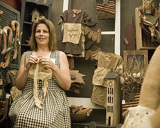 Debbie Forgac of N. Lima specializes in primitive folk art stitching. She's putting the finishing touches on an apron in her booth at the Shaker Craft Festival in Beaver Sunday, August 10, 2008. Daniel C. Britt.