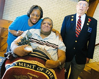 WARMTH: Marine Corps. Sgt. Charles Rhodes sits next to his sister Patsy Price of Youngstown under a lap robe provided by Louis LaCava, a member of the American Legion Austintown Memorial Post 301, at Austinwoods Nursing Center in Austintown. Rhodes, who served from 1968 to 1973, also holds a statue depicting the raising of the flag on Iwo Jima in World War II.