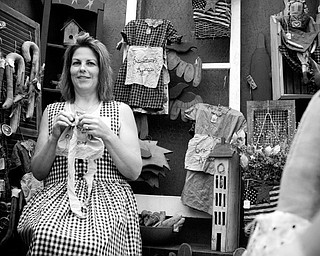 A STITCH IN TIME: Debbie Forgac of North Lima stitches an apron while dressed in traditional Shaker apparel. She took part in the Shaker Woods Festival in Columbiana on Sunday.