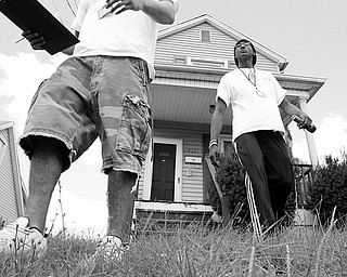 ANOTHER ATTEMPT: Girard meter readers Ben Belcik, left, and Brien Golden leave an Ohio Avenue house after unsuccessfully attempting to gain access to the water meter inside the home. The notification of their attempt hands from the mailbox in the background.