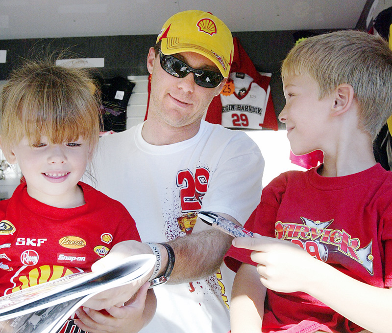 NASCAR driver Kevin Harvick signs autographs for Brooke Cascio, 4, left, and her brother Hunter, 8, at Sharon Speedway Tuesday. They were attending the event with their grandmother Nadine Atkinson of Greenville, Pa.