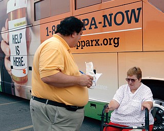 HELP IS HERE: Youngstown-area residents turned for help with their prescription medicine costs to the Help is Here Express, which was at the Youngstown Community Health Center on Wick Avenue. Trained specialist Thomas Townsend gathered information on Mary Murphy, who requires medication as the result of an auto accident several years ago.