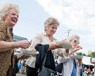 DELICIOUS: Friends Gloria Conman of Austintown, left, Jan Maglaughlin of Boardman and Lucille Brown of Youngstown enjoy a laugh and a slice of pizza during the Brier Hill Italian Festival in Youngstown on Thursday. The festival continues today through Sunday on Calvin and Victoria Streets.