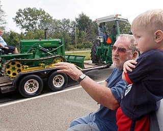 BIG WHEEL: Jim Wright and great-grandson Adrian Wilkes, 3, both of Braceville, watched an antique tractor parade Thursday afternoon along U.S. Route 422. The parade kicked off the annual show of the Antique Tractor Club of Trumbull County.