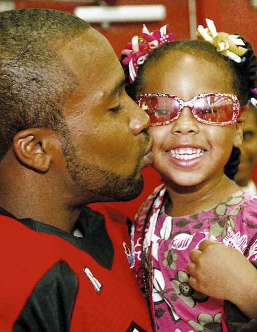 In this photo from Youngstown State's annual football media day in 2008, Tyler Griffin kisses his daughter.