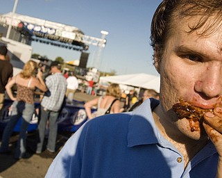 Sean Boughner, 22, of Boardman enjoying a rack of ribs at the Miller Lite National Rib Cook-Off Saturday, August 16, 2008 outside the Chevy Centre. Daniel C. Britt.
