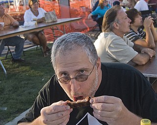 John Busco enjoys some Mojo hickory ribs at the rib fest Saturday, August 16, 2008. Daniel C. Britt.