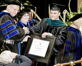 'I DID IT': Chris Denton Youngstown poses for a picture after accepting his doctorate in physical therapy at Youngstown State University's summer commencement in Beeghly Center. This is the first year the physical therapy program has issued doctoral certificates. At left is Peter Kasvinsky, associate provost for research and dean of the School of Graduate Studies and Research.
