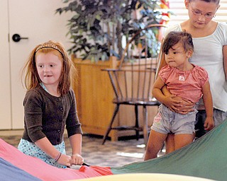 Elizabeth Hahn of Austintown (seen here on the left) is trying to keep the bug away from her during the parachute activity.