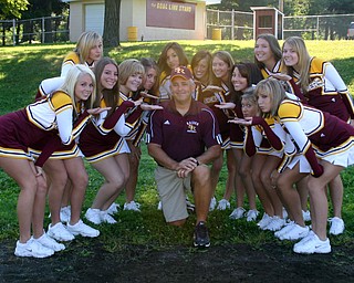 "South Range Coach Dan Yeagley takes time to pose with the Varsity
cheerleaders at a recent team photo day."
