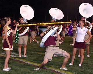 "Senior Jake Fry successfully limbos WITH A TUBA during the South
Range Raider Band show at halftime Friday evening.  Senior flagline
members Whitney Gould and Lyndsey Cramer hold the limbo pole."