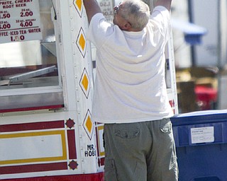 HANGIN in THERE - Bob Taylor of Cortland hangs his signs on his booth at the Canfield Fair - the Fair opens tomorrow - robertkyosay